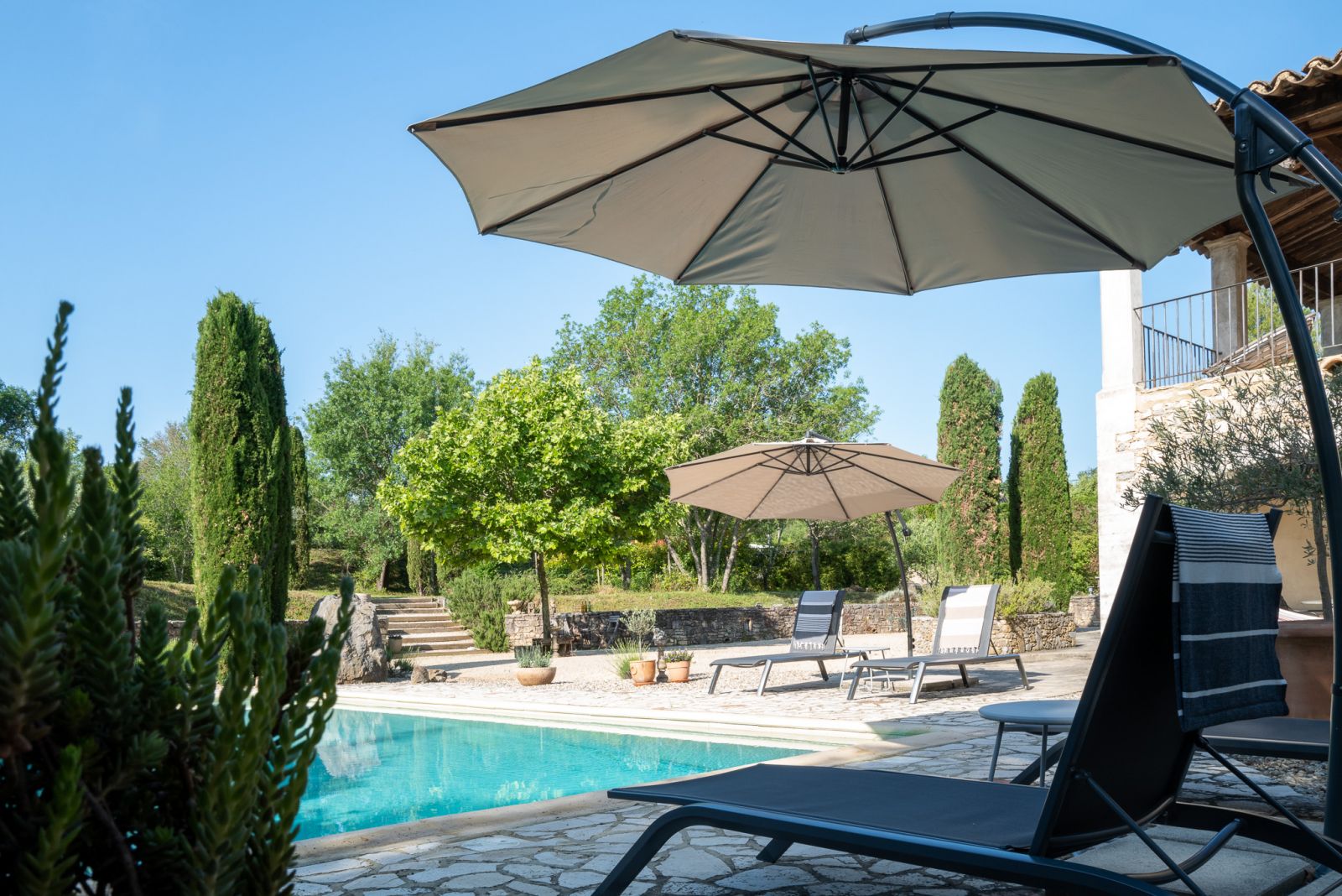 sZwembad met diverse sets met ligstoelen en parasols