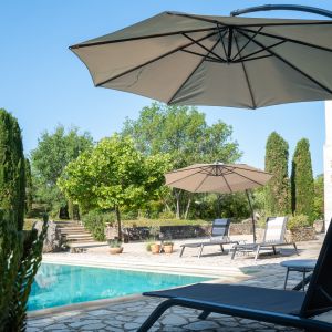 Zwembad met diverse sets met ligstoelen en parasols